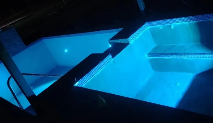 Piscina iluminada de noche con luces LED azules