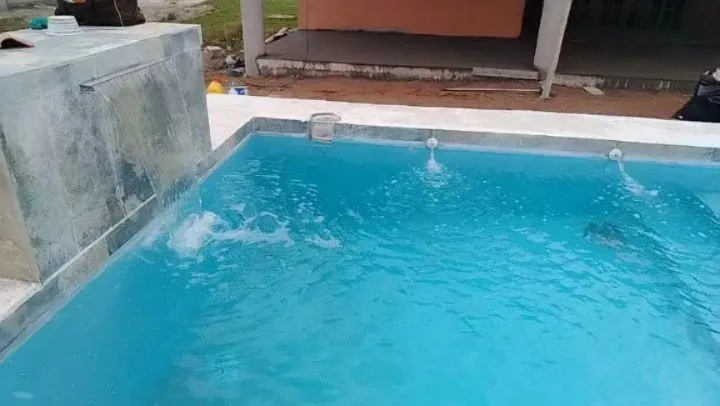 Piscina con chorros de agua y acabado claro en Coclé