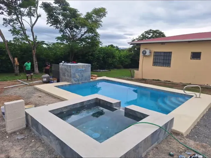 Piscina con jacuzzi elevado y deck de madera