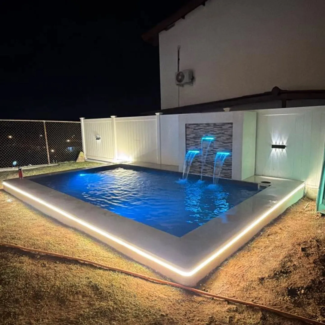 Piscina moderna con iluminación LED perimetral vista de noche