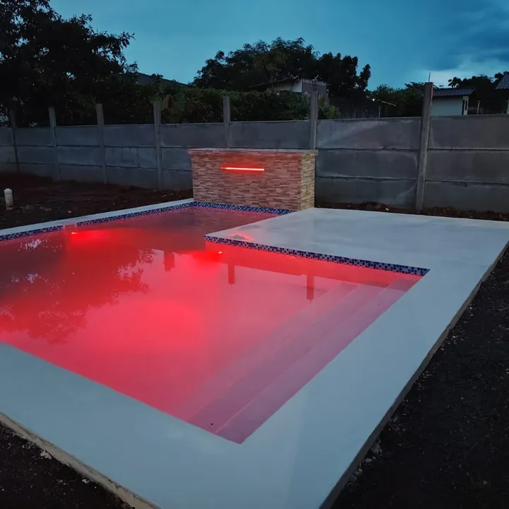 Piscina iluminada con luces LED de color en la noche